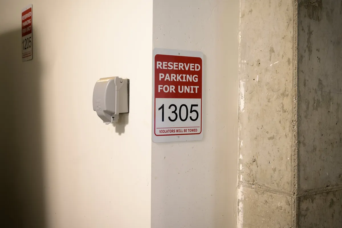 A reserved parking sign and unit number 1305 are shown against a concrete wall, evoking the convenience and security of underground parking. The image hints at accessibility and ease for residents returning from snowy adventures or group outings.